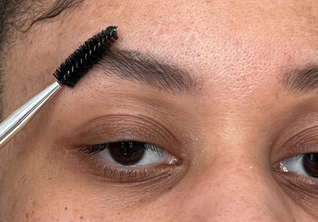 Spoolie brush brushing dark brow tint through brow hair