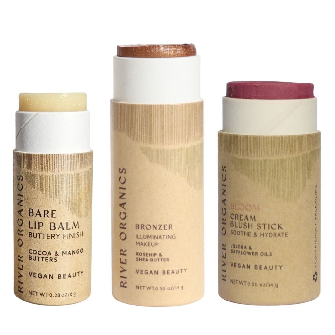 River Organics Lip + Highlighter + Blush Set features three cylindrical, push-up vegan beauty sticks in plastic-free packaging with minimal labels—ideal for a clean, eco-friendly beauty routine.