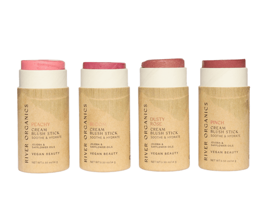 River Organics Creamy Vegan Blush Sticks | Set of 2 Mix & Match come in zero-waste cardboard tubes labeled with shades like Peachy, Bloom, Dusty Rose, and Pinch. The cream blush tops are exposed to showcase their vibrant colors.
