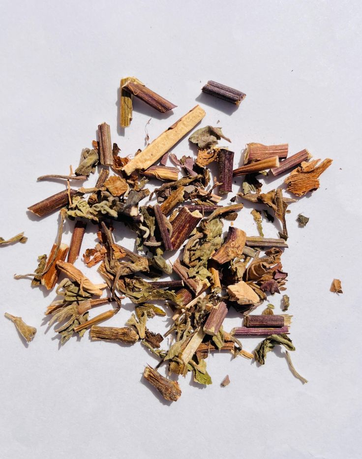 A blend of dried herbs, leaves, and stems in brown, green, and purple—perfect for crafting the "Roseth: Rose + Patchouli - Botanical Scent Balm" by River Organics.