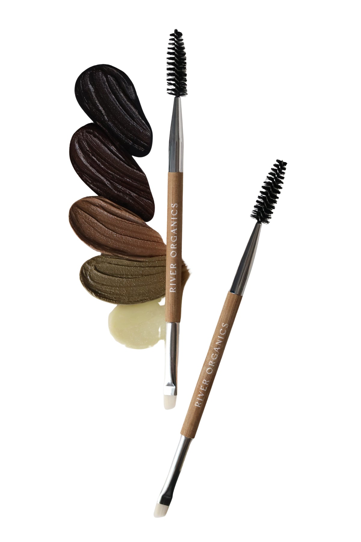 Two "River Organics" dual-ended brushes rest on swatches of four brow wax shades—dark brown, brown, taupe, and clear—beside the Eye Duo Set: Brow Wax + Zero-waste Mascara, perfect for your vegan eye routine.