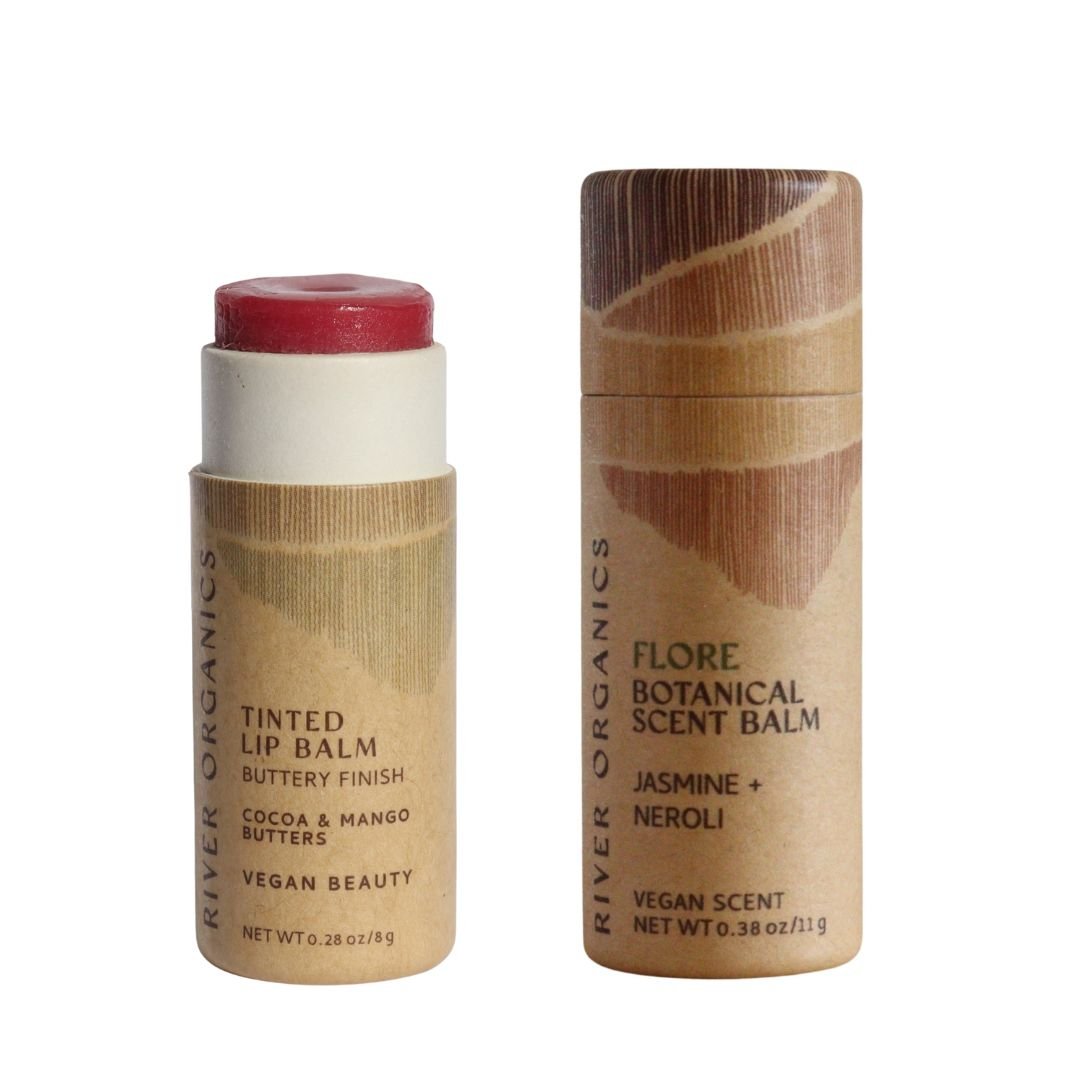 River Organics' Lip + Scent Balm Bundle features two cylindrical tubes with minimalist brown labels, both made from natural, vegan ingredients—your botanical ritual for lips and scent in one eco-friendly set.