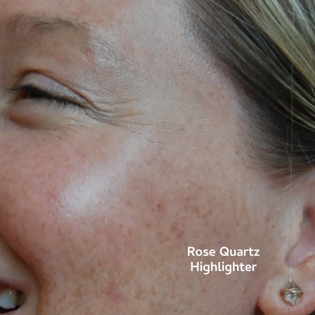 Close-up of a smiling person's cheek and ear, showcasing radiant skin enhanced with River Organics’ Highlighter and Bronzer Set. The words "Highlighter and Bronzer Set" appear near the cheekbone. The person wears a small gold earring.
