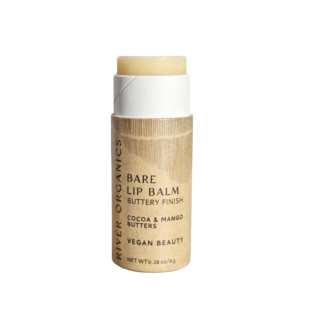 A tube of River Organics Bare Lip Balm Bundles with the cap off reveals the light balm. The label highlights cocoa and mango butters, notes its vegan formula, buttery finish, and features zero-waste packaging.