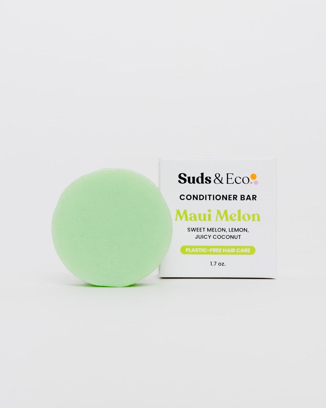 A round, light green vegan conditioner bar from ZeroWasteStore.com sits by its box labeled "Conditioner Bar, Maui Melon, Sweet Melon, Lemon, Juicy Coconut, Plastic-Free Hair Care, 1.7 oz." on a white background.