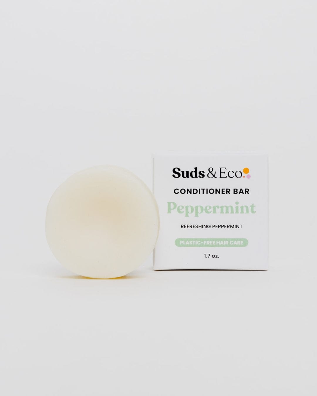 A round, white Conditioner Bar from ZeroWasteStore.com sits beside a white box labeled "Conditioner Bar" on a plain background—an ideal plastic-free, vegan conditioner perfect for eco-conscious hair care routines.