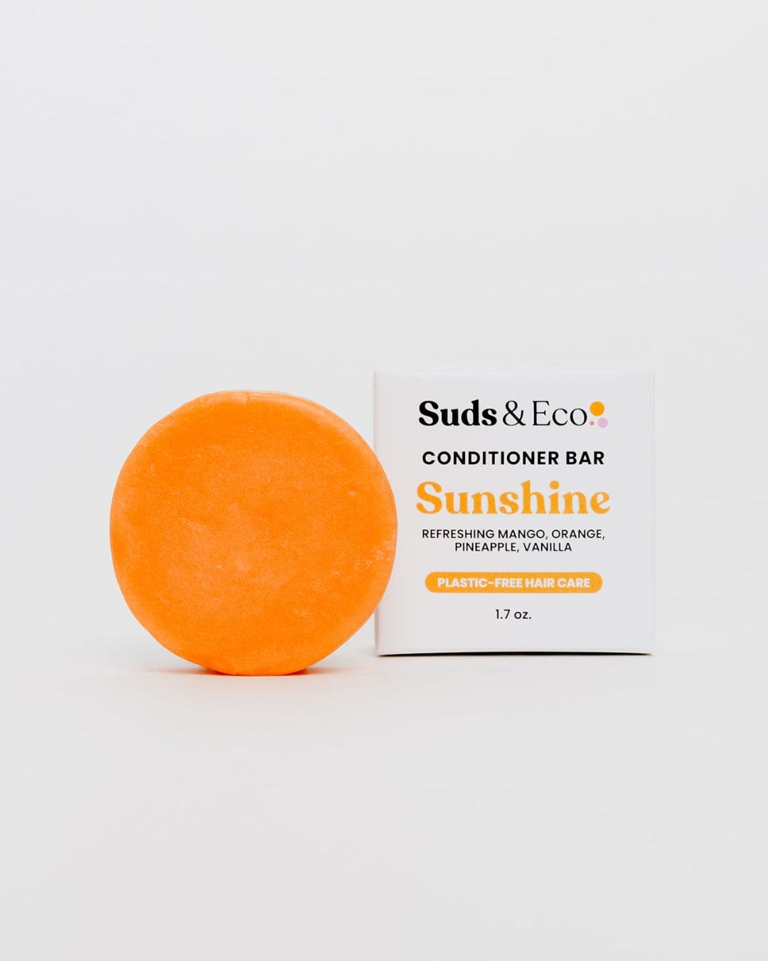 An orange Conditioner Bar from ZeroWasteStore.com sits by its box labeled "Conditioner Bar Sunshine; Refreshing Mango, Orange, Pineapple, Vanilla; Plastic-Free & Sulfate Free Hair Care; 1.7 oz," set against a white background.