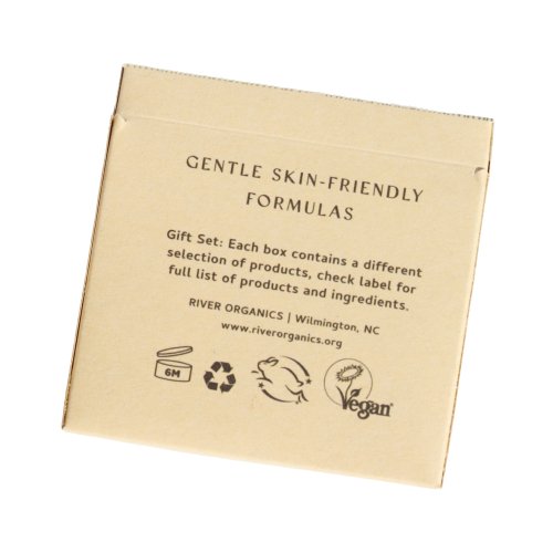 Close-up of a beige Gift Box labeled "Gentle Skin-Friendly Formulas," featuring assorted products with recycling and vegan symbols. It lists "River Organics, Wilmington, NC" along with a website link for more details.