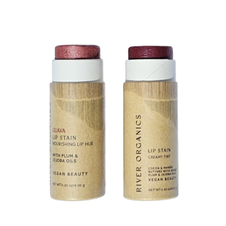 A cylindrical lip balm tube with a wooden texture and an off-white label saying "ORGANICS"; its cap is removed, revealing a deep red balm, both casting shadows on a white surface.