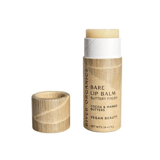 A Bare Vegan Lip Balm by River Organics with its cap off, showing the balm stick. The brown paper tube highlights that it contains cocoa and mango butters and is a vegan option for natural beauty.