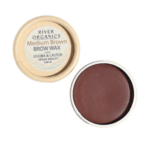 A small open container of River Organics Brow Wax - Tame, Tint & Grow reveals smooth medium brown vegan wax made with jojoba and castor, labeled as a sustainable beauty solution.