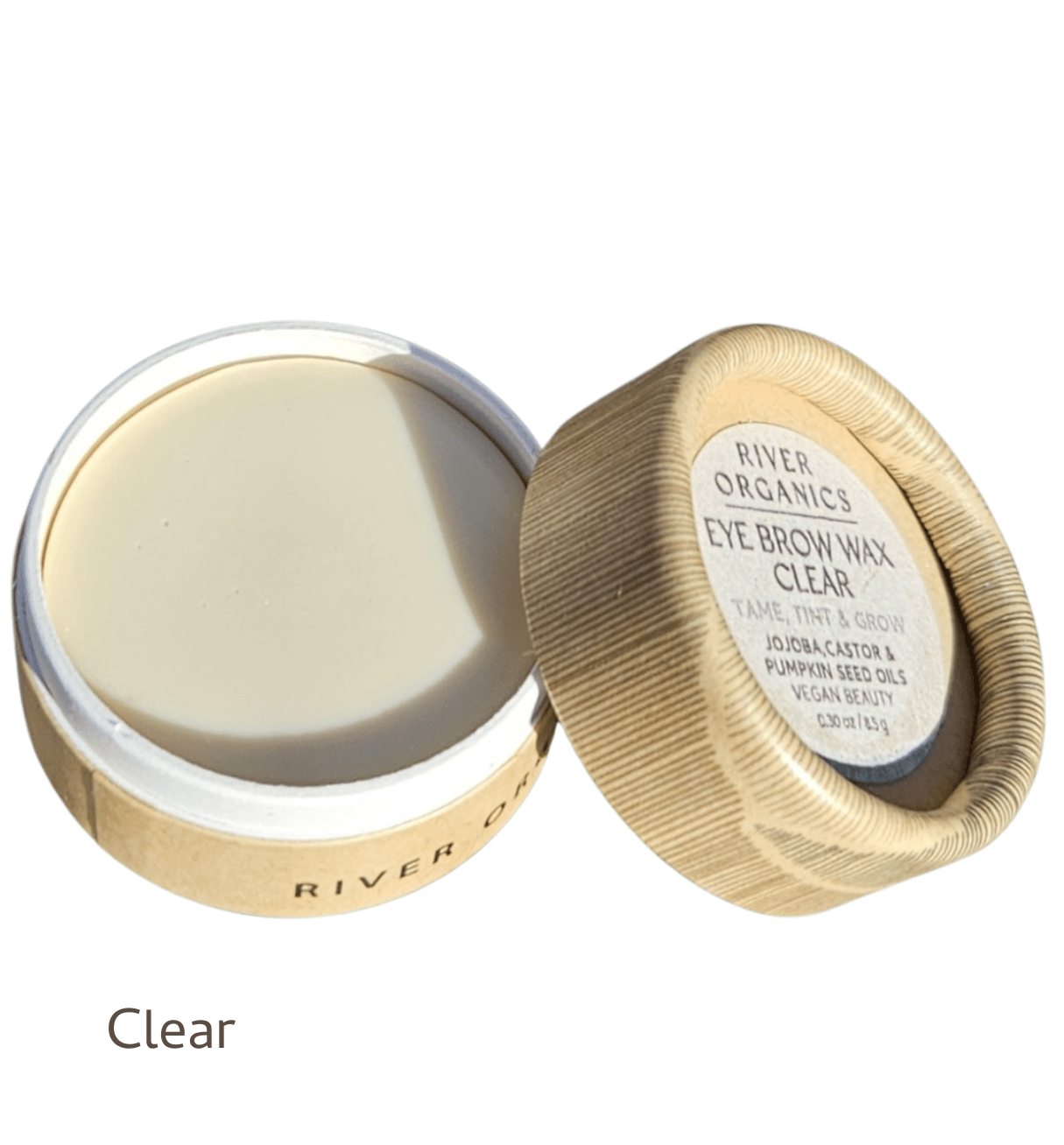A small round container of River Organics Brow Wax - Tame, Tint & Grow sits with its lid partially off, revealing the smooth vegan wax inside. The label highlights its brow taming, tinting, and growth benefits.