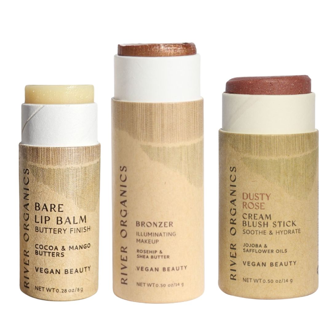 River Organics’ Lip + Highlighter + Blush Set features three eco-friendly cardboard tubes with minimalist tan labels, offering clean, vegan beauty formulas and plastic-free packaging.