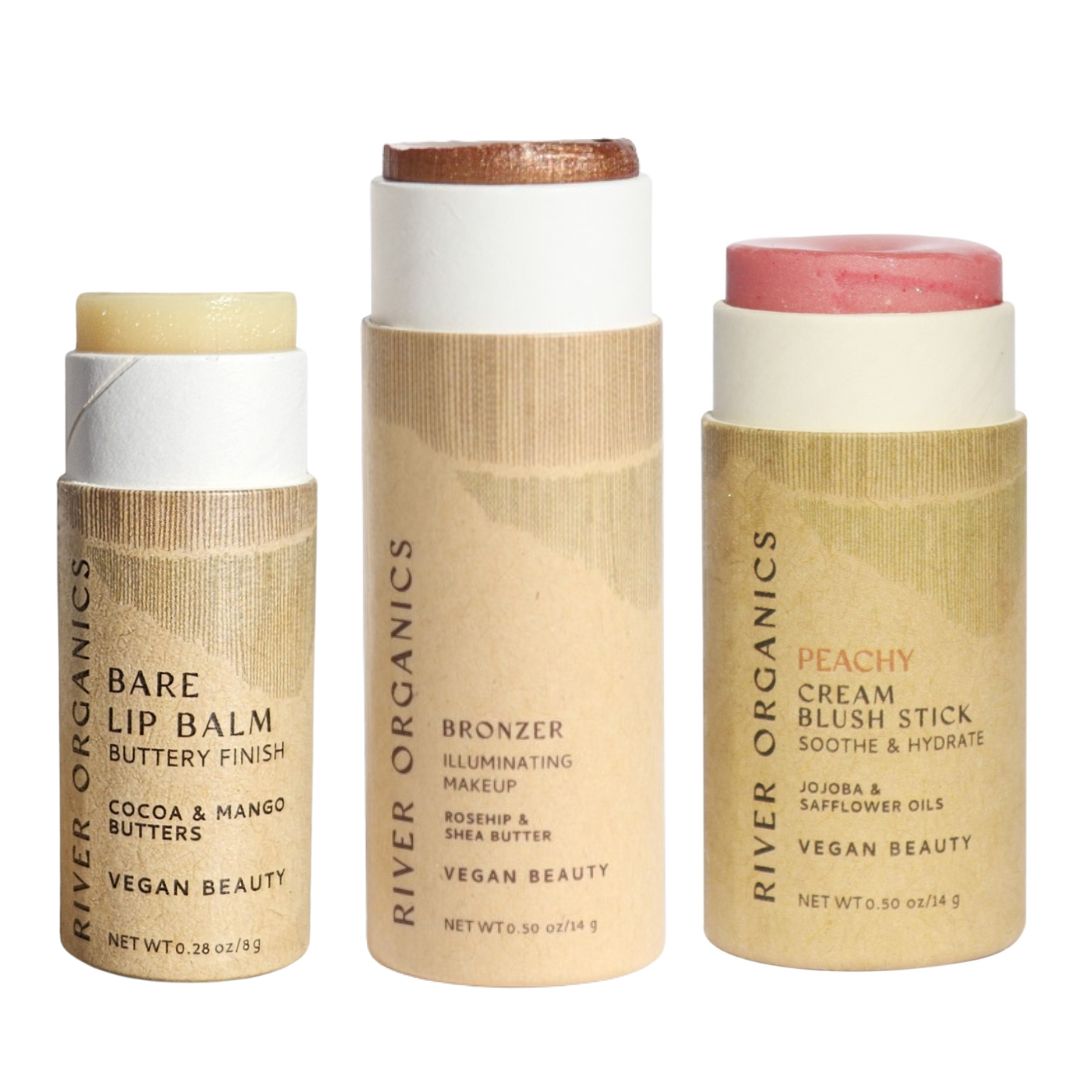 River Organics’ Lip + Highlighter + Blush Set features vegan beauty essentials in plastic-free packaging, side by side and ready for a clean beauty routine against a white background.