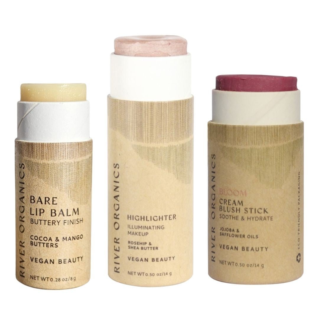 The River Organics Lip + Highlighter + Blush Set features a beige Bare Lip Balm, shimmery Highlighter, and pink Bloom Cream Blush Stick in plastic-free packaging with minimalist labels—perfect for a clean, customizable beauty routine.
