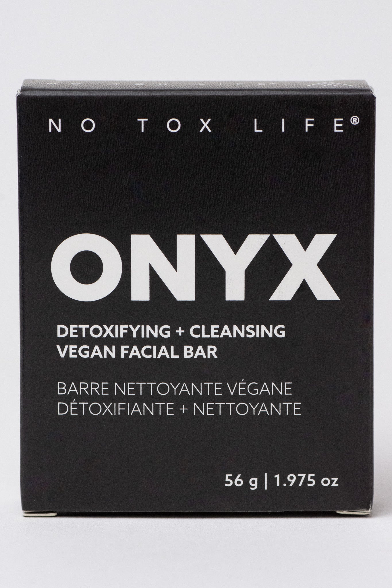 A black box labeled "NO TOX LIFE SOLIDSILK® ONYX - Facial Cleansing Bar" displays "Detoxifying + Cleansing Vegan Facial Bar with activated charcoal" in English and French, plus "56 g | 1.975 oz" at the bottom.