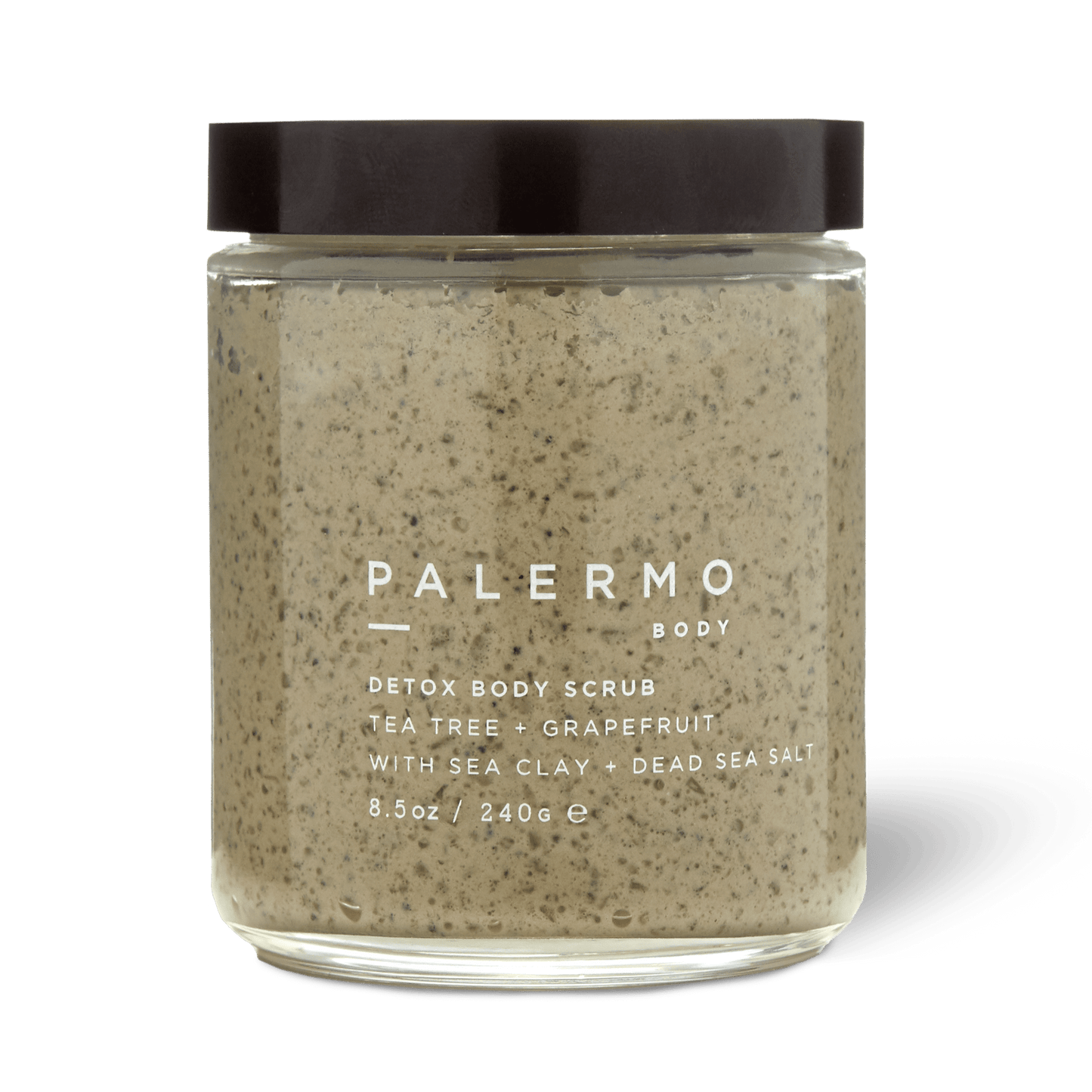 Palermo Body's Detox Body Scrub comes in a clear glass jar with a black lid. The label highlights Dead Sea salt, sea clay, tea tree, and grapefruit. Inside is a beige scrub with visible speckles for an invigorating cleanse.
