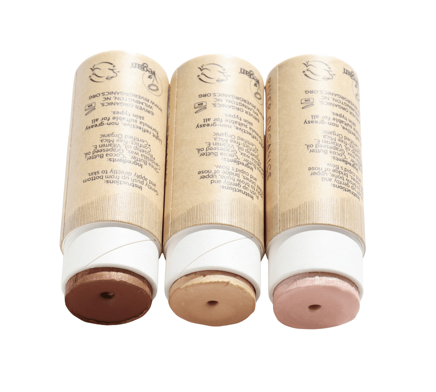 Three tubes of River Organics' Highlighter and Bronzer Set are aligned horizontally, each in a cardboard container with visible shades at the open end: dark brown, light beige, and pale pink. Made from vegan, non-toxic ingredients for a guilt-free beauty routine.