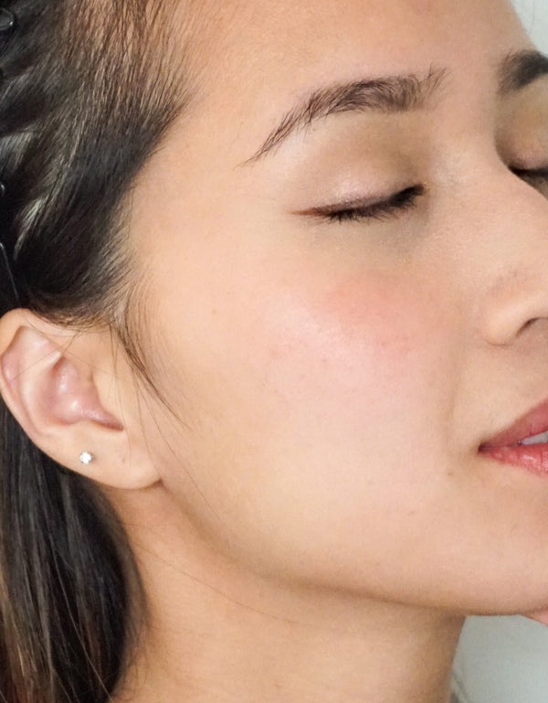 Close-up profile of a person wearing River Organics Natural Cream Blush Stick in a subtle peachy-pink shade on their cheek.