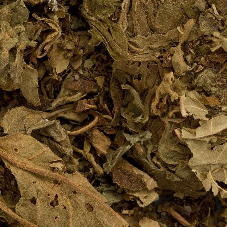 Close-up of dried, crumpled leaves in brown and green tones, with detailed textures—evoking the earthy notes of Roseth: Rose + Patchouli Botanical Scent Balm by River Organics.