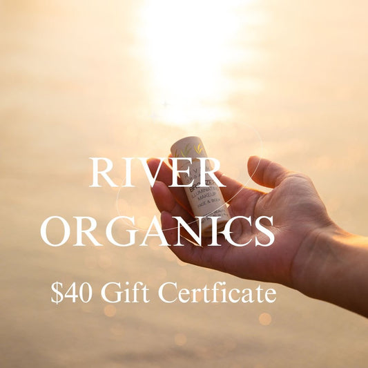 A hand holds a small tube in warm sunlight over water. Text reads "River Organics $40 Gift Card" by River Organics.