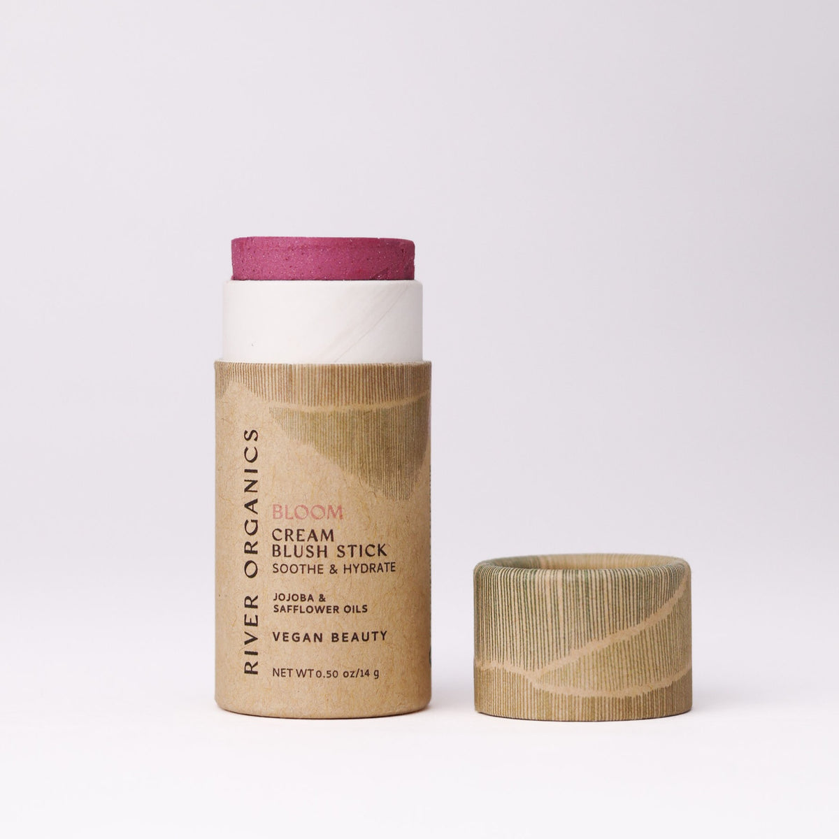 A River Organics Natural Cream Blush Stick in a paper tube with the cap removed, showing a deep pink blush.
