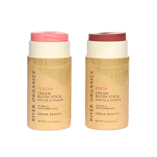 Two cardboard tubes branded “River Organics” showcase the Set of 2 | Natural Cream Blush Sticks—one in peach and one in deep rose. These zero-waste, vegan blush essentials feature hydrating jojoba and safflower oils, making them as gentle on your skin as they are on the planet.