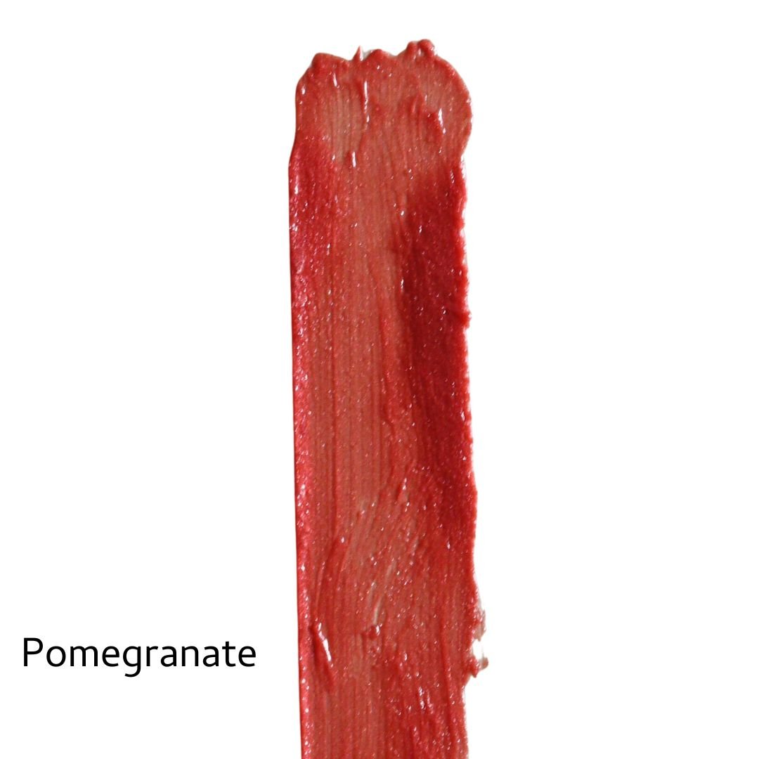 A glossy red swatch labeled "Pomegranate" on white showcases River Organics Vegan Lip Stains, delivering bold, organic color with a natural finish.