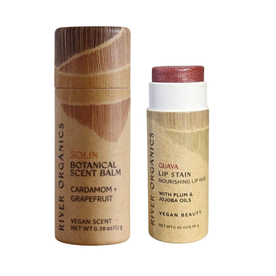 River Organics' Lip + Scent Balm Bundle includes two cylindrical tubes—one botanical scent balm and one vegan lip balm—featuring natural, minimalist packaging for your daily ritual.