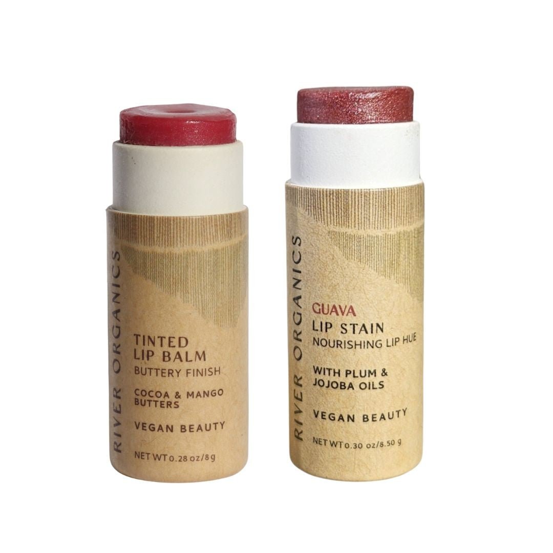 River Organics Set of 2 Lip Balms or Lip Stains: includes a vegan, hydrating balm with reddish tint and a pink lip stain. Both come in white containers with brown paper labels, emphasizing natural beauty and organic ingredients.