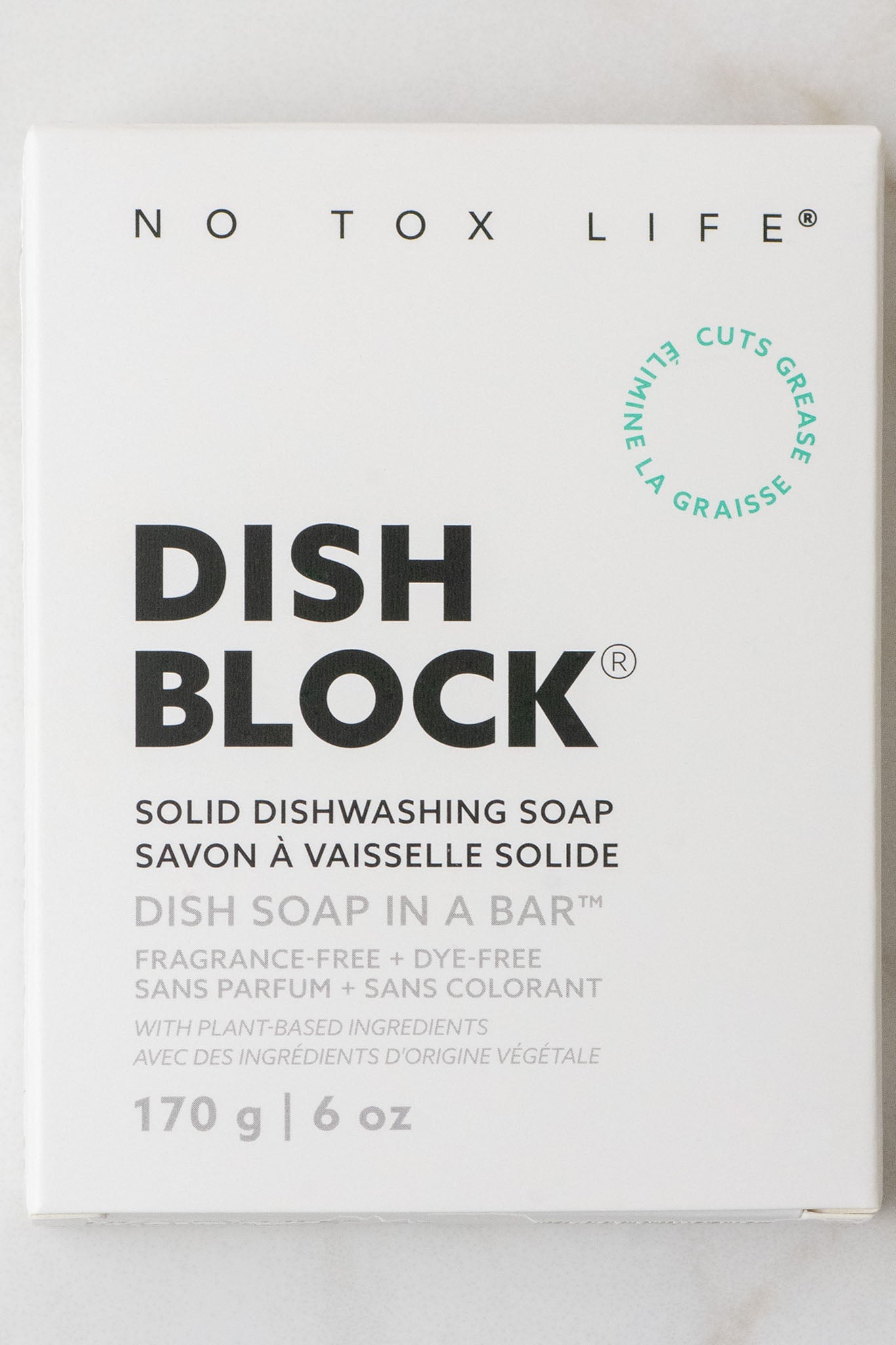 A white box of No Tox Life DISH BLOCK® solid dish soap (6 oz/170g)—a vegan, plant-based, fragrance- and dye-free multipurpose cleaning bar. The minimalist packaging features black and green text.