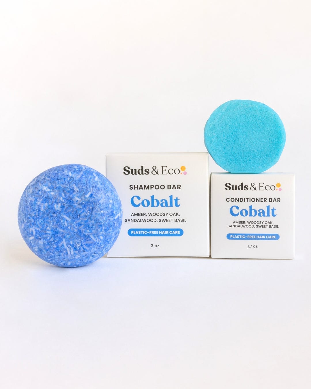 Two blue Shampoo & Conditioner Bar Duo sets from ZeroWasteStore.com are displayed with matching white boxes. These zero-waste bars offer amber, oak, sandalwood, and basil scents for a plastic-free hair care routine.