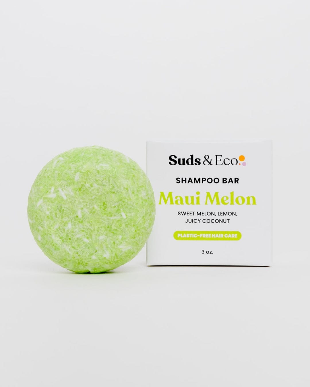 A round, light green ZeroWasteStore.com Shampoo Bar is placed beside its packaging labeled "Shampoo Bar. Maui Melon. Sweet Melon, Lemon, Juicy Coconut. Plastic-Free Hair Care. 3 oz." on a plain white background.