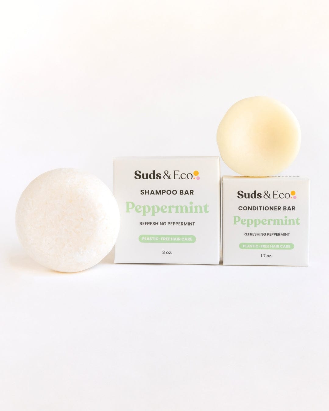 The ZeroWasteStore.com Shampoo & Conditioner Bar Duo, featuring a round and a dome-shaped white bar in labeled boxes, showcases zero waste hair care on a white background.
