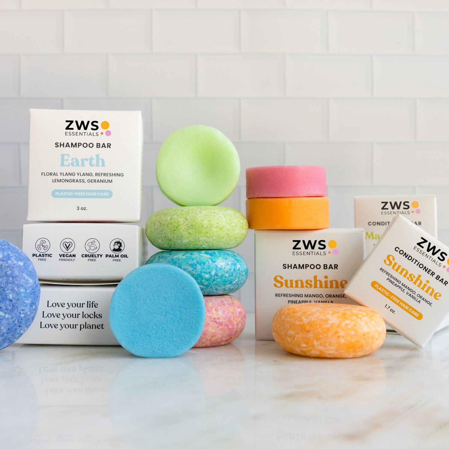 Shampoo & Conditioner Bar Duo bars from ZeroWasteStore.com are stacked on a white surface with branded boxes behind them, their vibrant colors and clean backdrop emphasizing the products’ zero waste appeal.