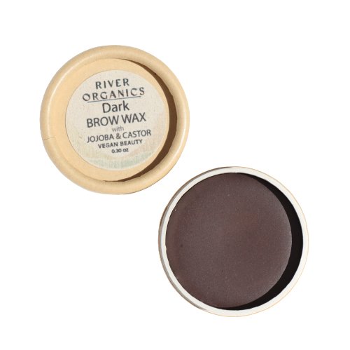 A small, round container of River Organics Tinted Vegan Shaping Eyebrow Wax | Dark with Jojoba & Castor. The lid is off and placed beside the base, revealing a dark vegan brow wax inside. The product is labeled as vegan and beauty, weighing 0.28 oz. The natural beige container complements its natural brow color perfectly.