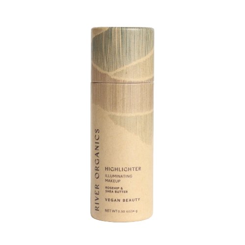 A cylindrical cardboard container of River Organics Skincare Vegan Highlighter Stick | Rose Quartz stands against a white background. The beige and green packaging, labeled as illuminizing makeup with rosehip and shea butter, features nourishing plant oils. This vegan certified product weighs 0.35 ounces.