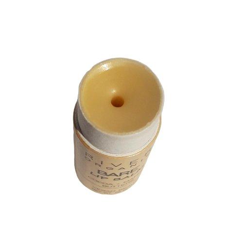 A cylindrical Bare Vegan Lip Balm by River Organics with a tan cap and light-colored body. The top of the cap is open, revealing the ultra hydrating lip balm stick inside. There is a small hole in the center of the balm.